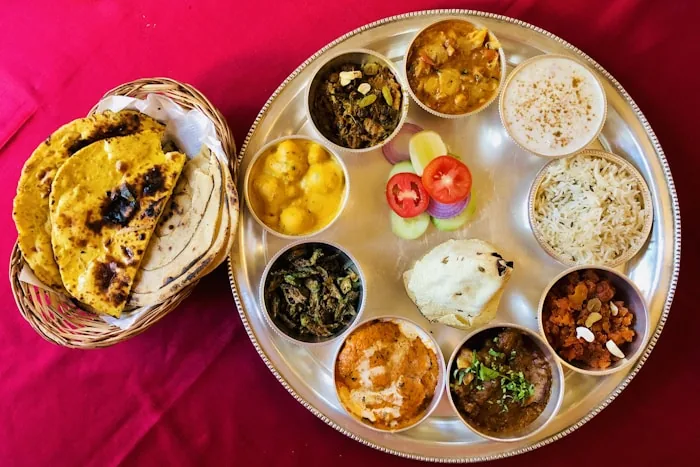 An Indian thali with rice, curries and breads on a steel tray