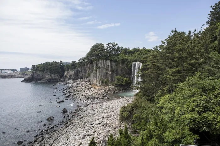 Volcanic cliffs and a waterfall on the coast of Jeju Island