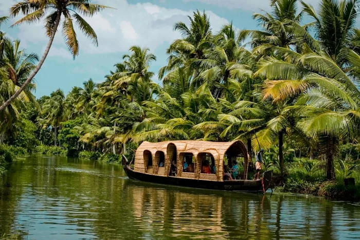 A houseboat on the Kerala backwaters lined with palm trees